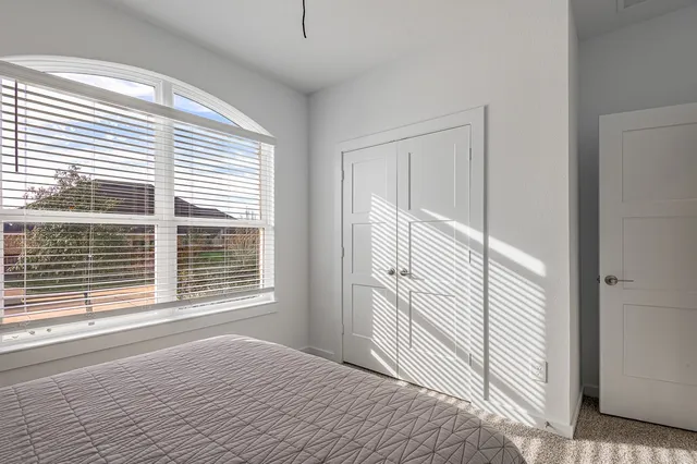 a view of a bedroom with a window and a bathroom