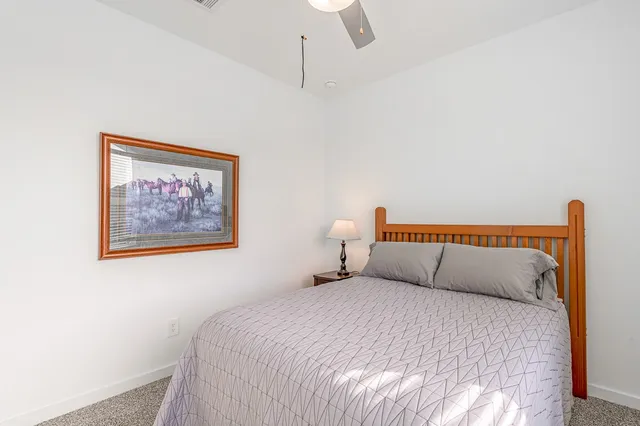 a bedroom with a bed and a painting on the wall