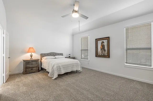 a spacious bedroom with a bed and a chandelier