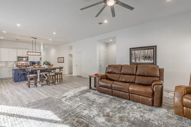 a living room with furniture and kitchen view