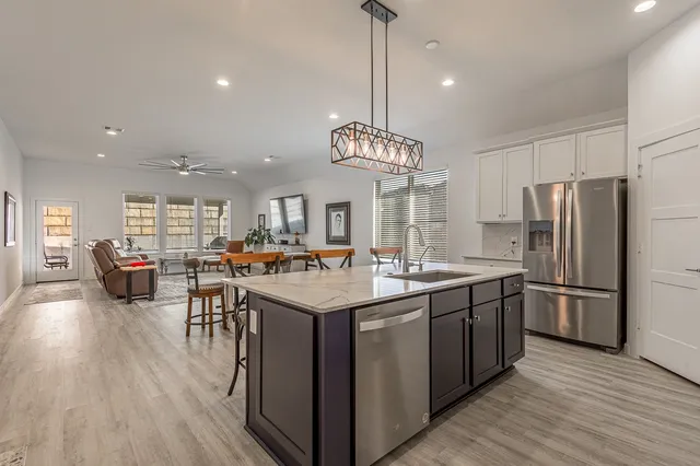a kitchen with stainless steel appliances granite countertop a sink a stove and a refrigerator