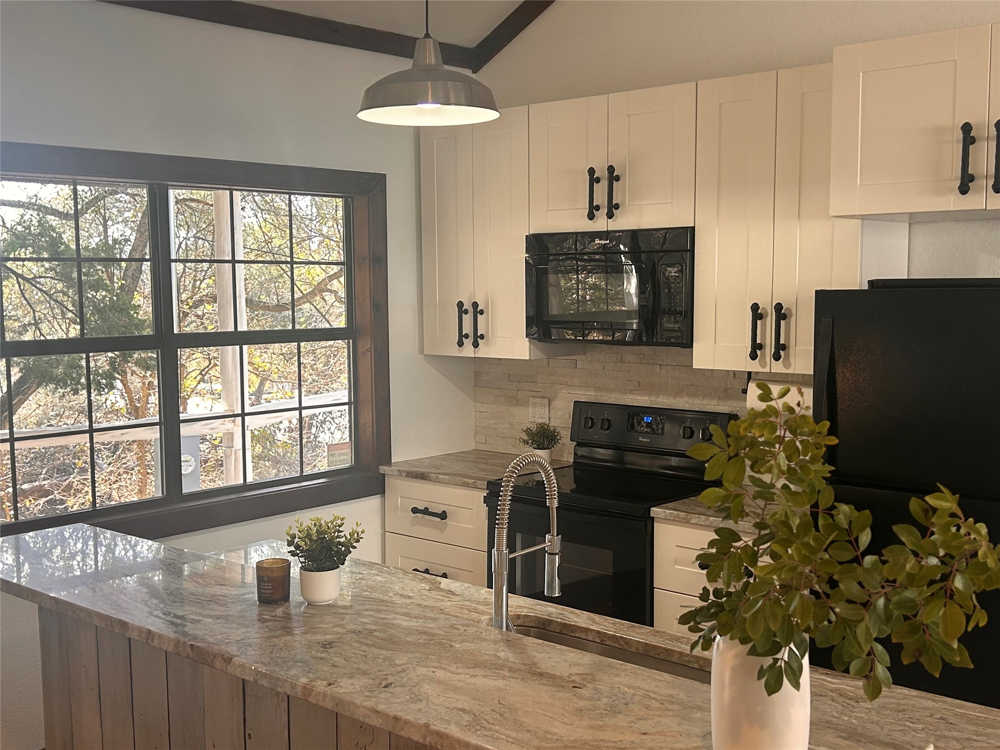 15104 Texas Street Austin, TX 78734 - Photo 4 of 18 a kitchen with stainless steel appliances granite countertop a stove a sink and a microwave