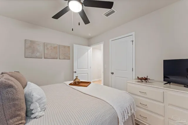 a bedroom with a bed and a flat tv screen on the dresser