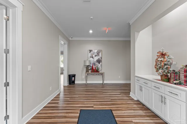 a hallway with wooden floor and staircase