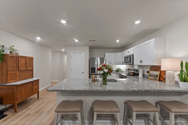 a kitchen with granite countertop a counter space dining table and stainless steel appliances