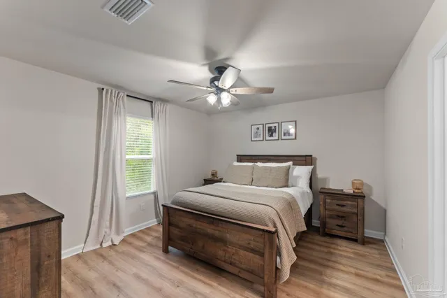 a bedroom with a bed and a ceiling fan