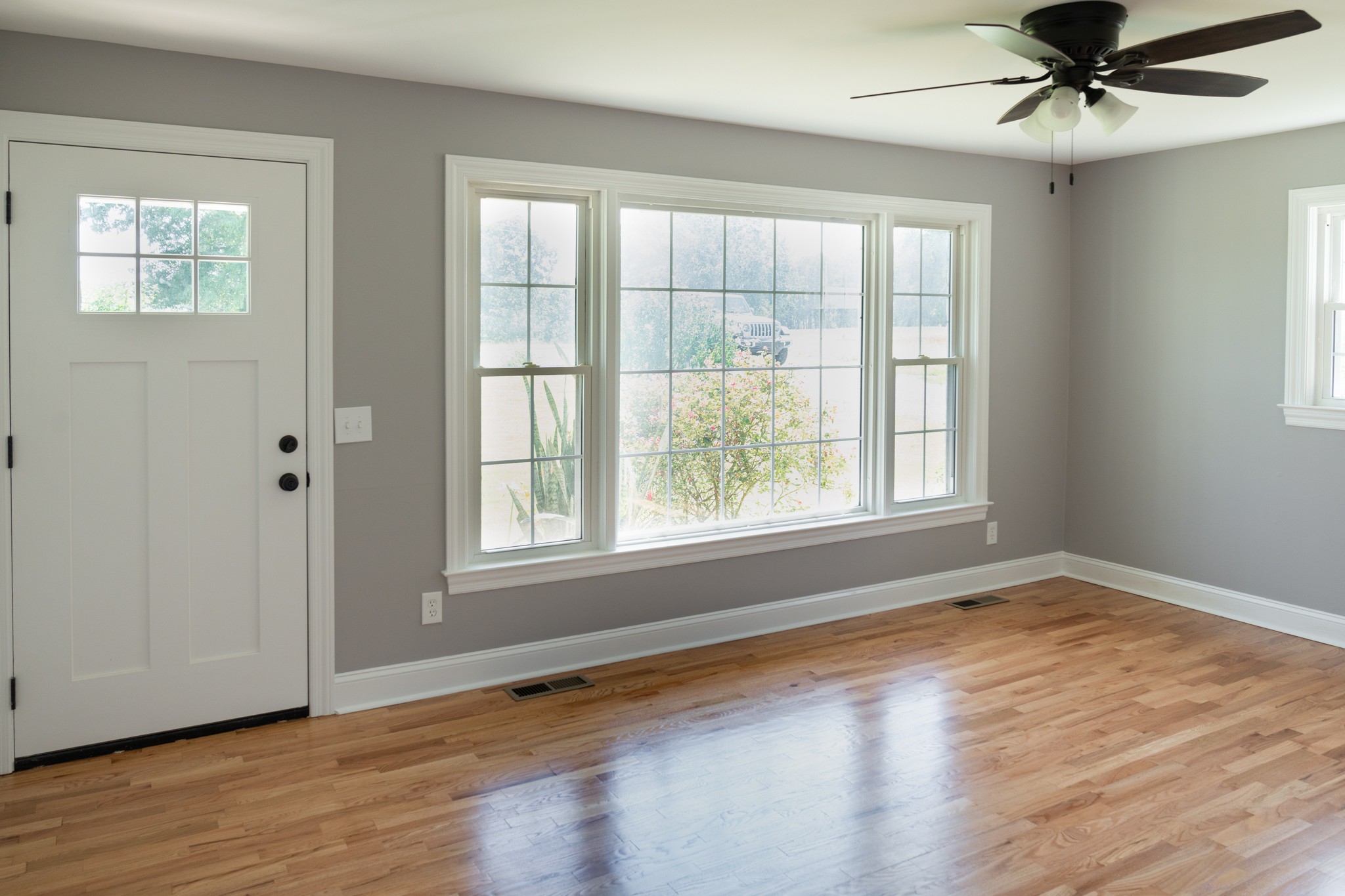 239 Durham Road Leoma, TN 38468 - Photo 3 of 10 an empty room with wooden floor fan and windows