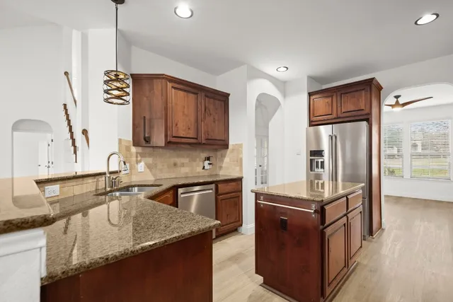 a kitchen with stainless steel appliances granite countertop a sink stove and refrigerator