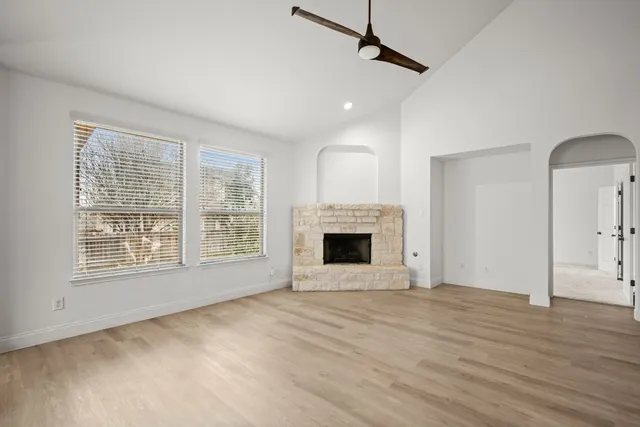a view of an empty room with a fireplace and a window