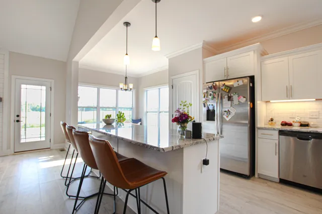 a kitchen with refrigerator and wooden floor