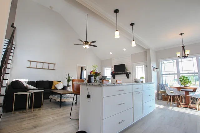 a kitchen with a dining table chairs wooden floor and appliances