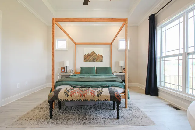 a bed sitting in a bedroom next to a window