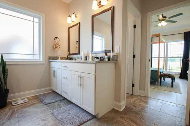 a view of a bathroom with mirror and window
