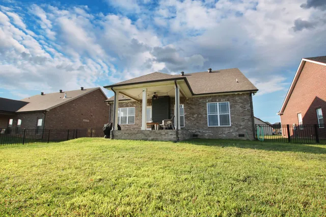 a view of a house with a big yard and a large tree