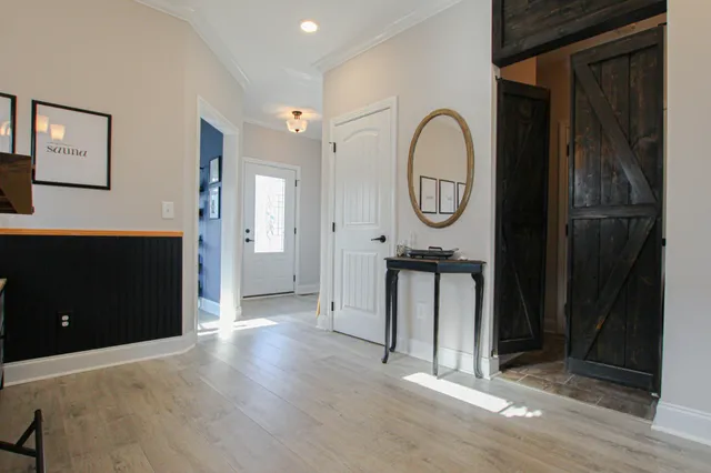 a view of a hallway with wooden floor and entryway