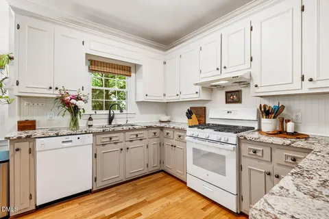 a kitchen with stainless steel appliances granite countertop a white cabinets stove a sink and dishwasher