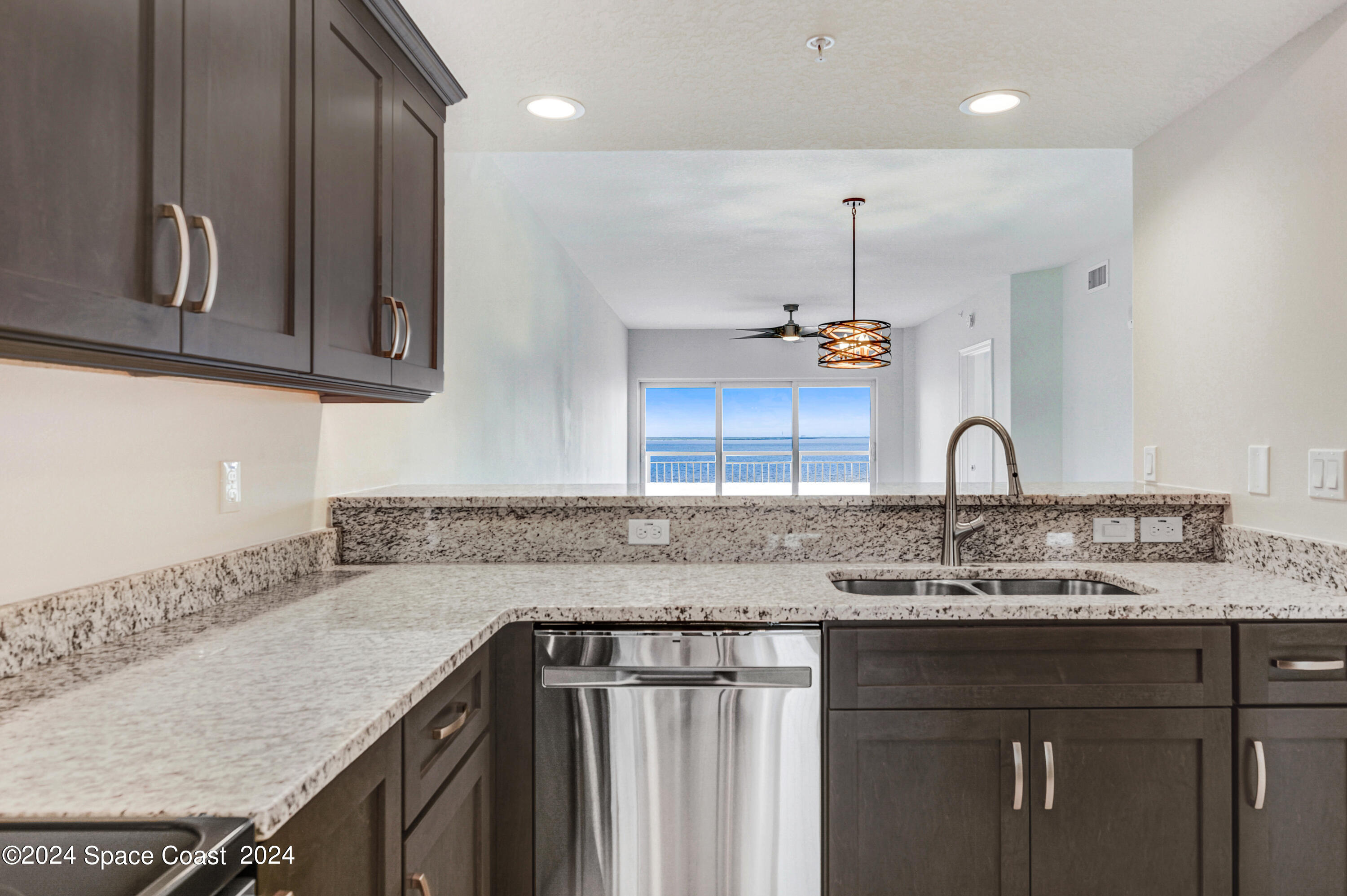 1805 Riverside Drive, Unit 606 Titusville, FL 32780 - Photo 13 of 40 a kitchen with kitchen island granite countertop a sink a stove and cabinets