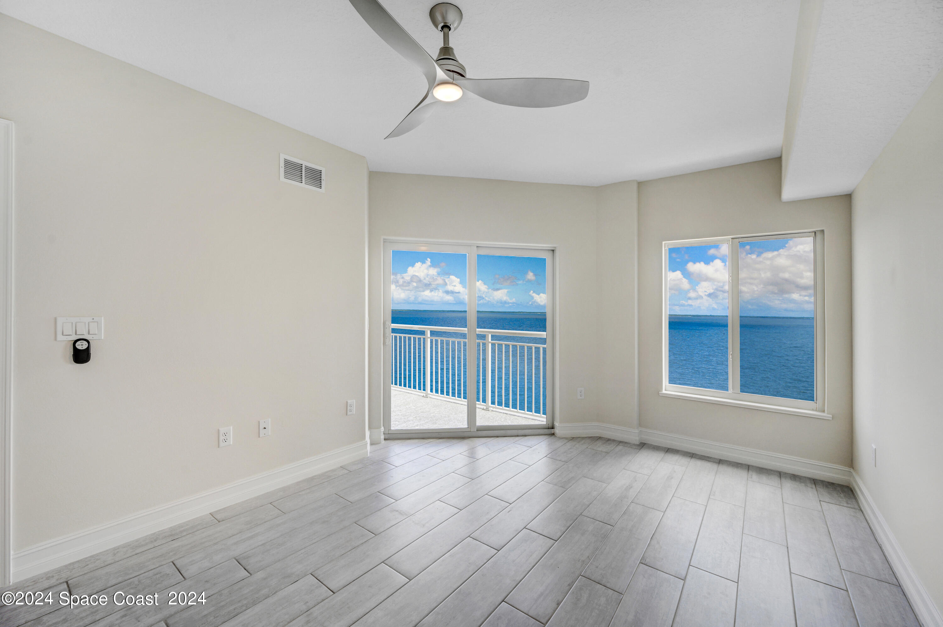1805 Riverside Drive, Unit 606 Titusville, FL 32780 - Photo 18 of 40 a view of an empty room with wooden floor and a window