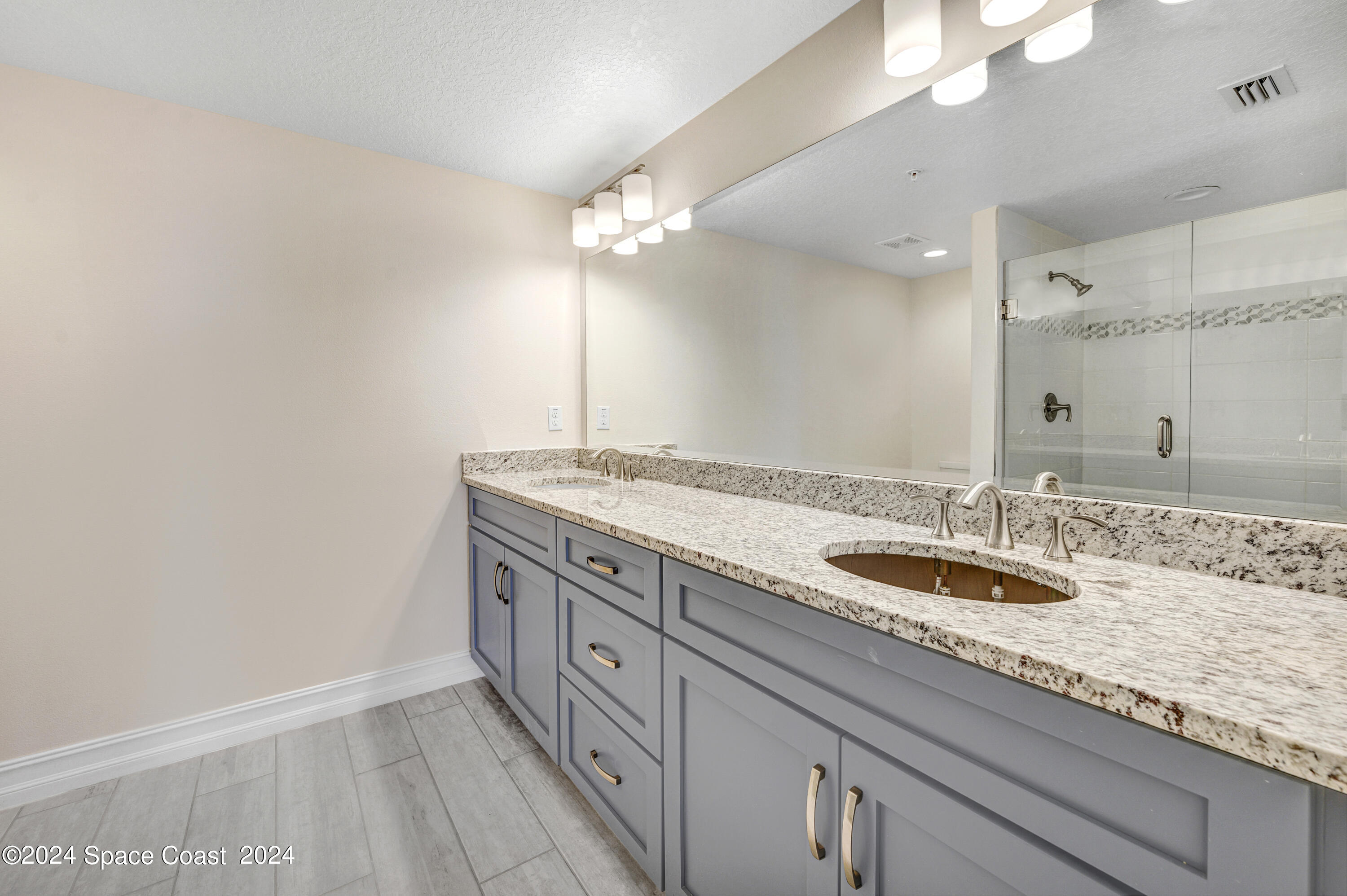 1805 Riverside Drive, Unit 606 Titusville, FL 32780 - Photo 19 of 40 a bathroom with a granite countertop double vanity and a mirror