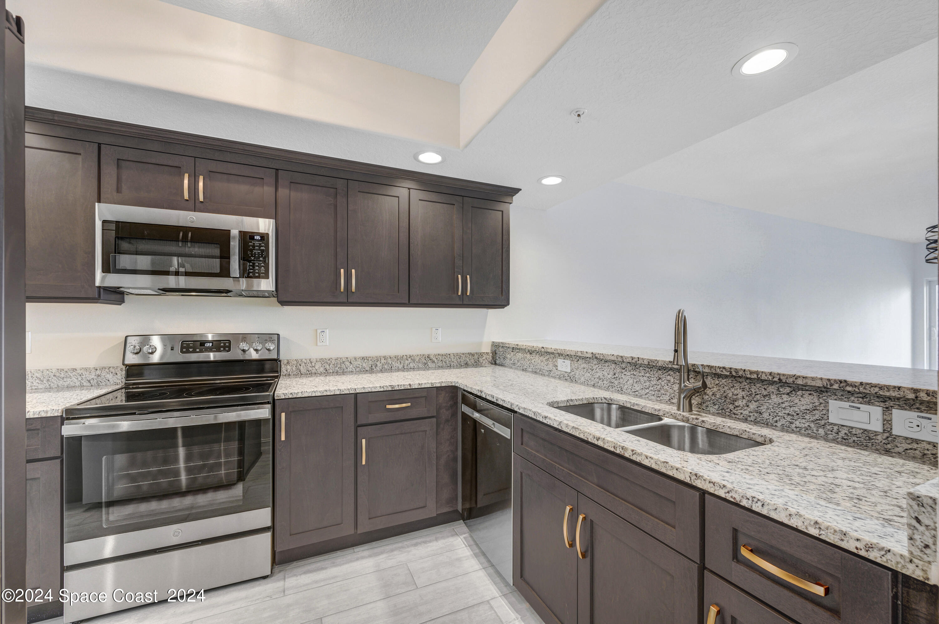 1805 Riverside Drive, Unit 606 Titusville, FL 32780 - Photo 9 of 40 a kitchen with a sink stove and microwave