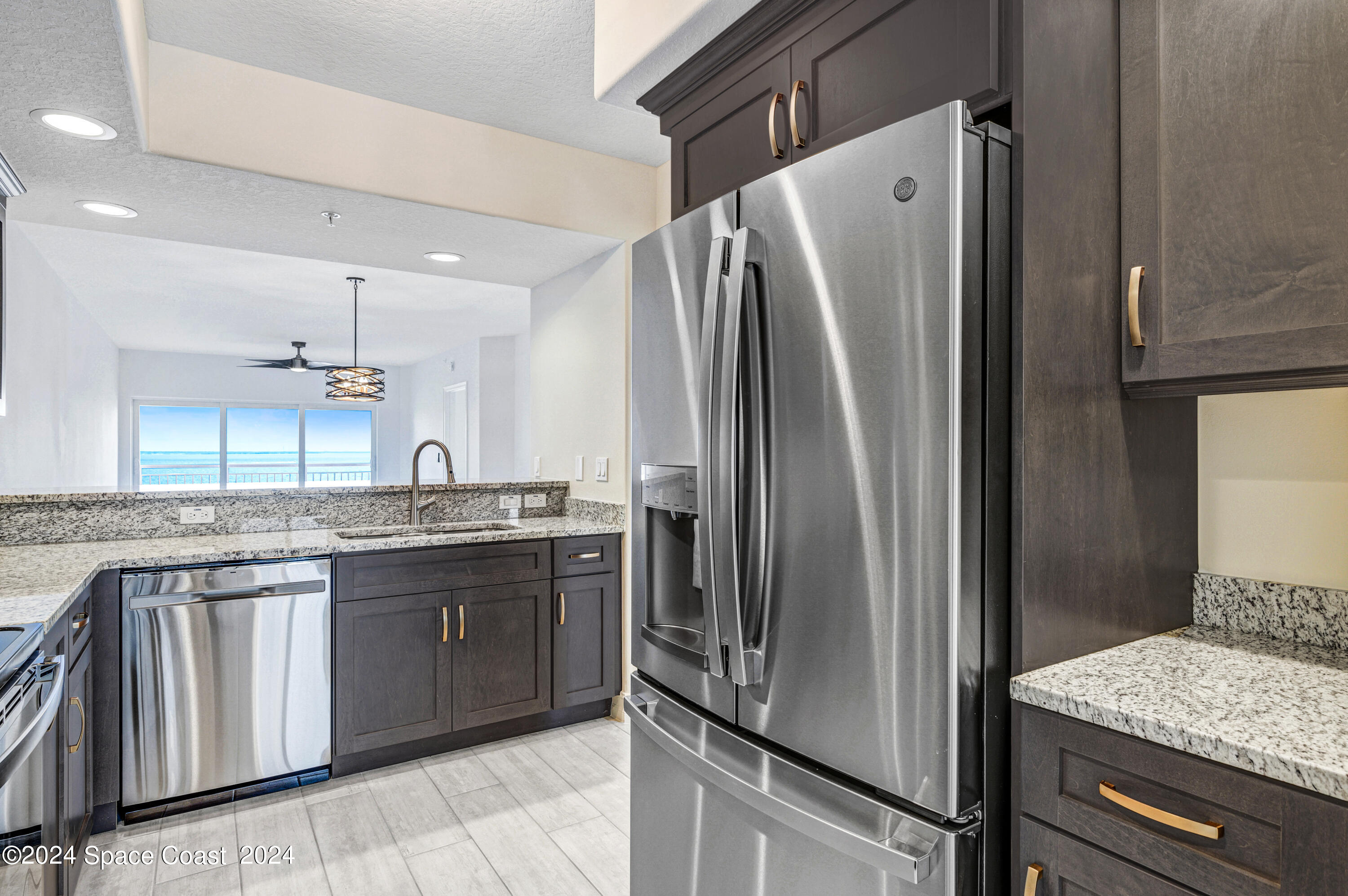 1805 Riverside Drive, Unit 606 Titusville, FL 32780 - Photo 10 of 40 a kitchen with stainless steel appliances granite countertop a refrigerator and a sink