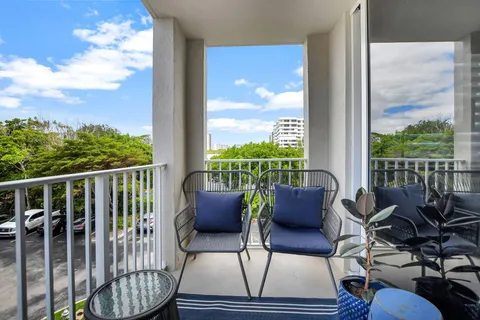 a balcony with chairs and a potted plant