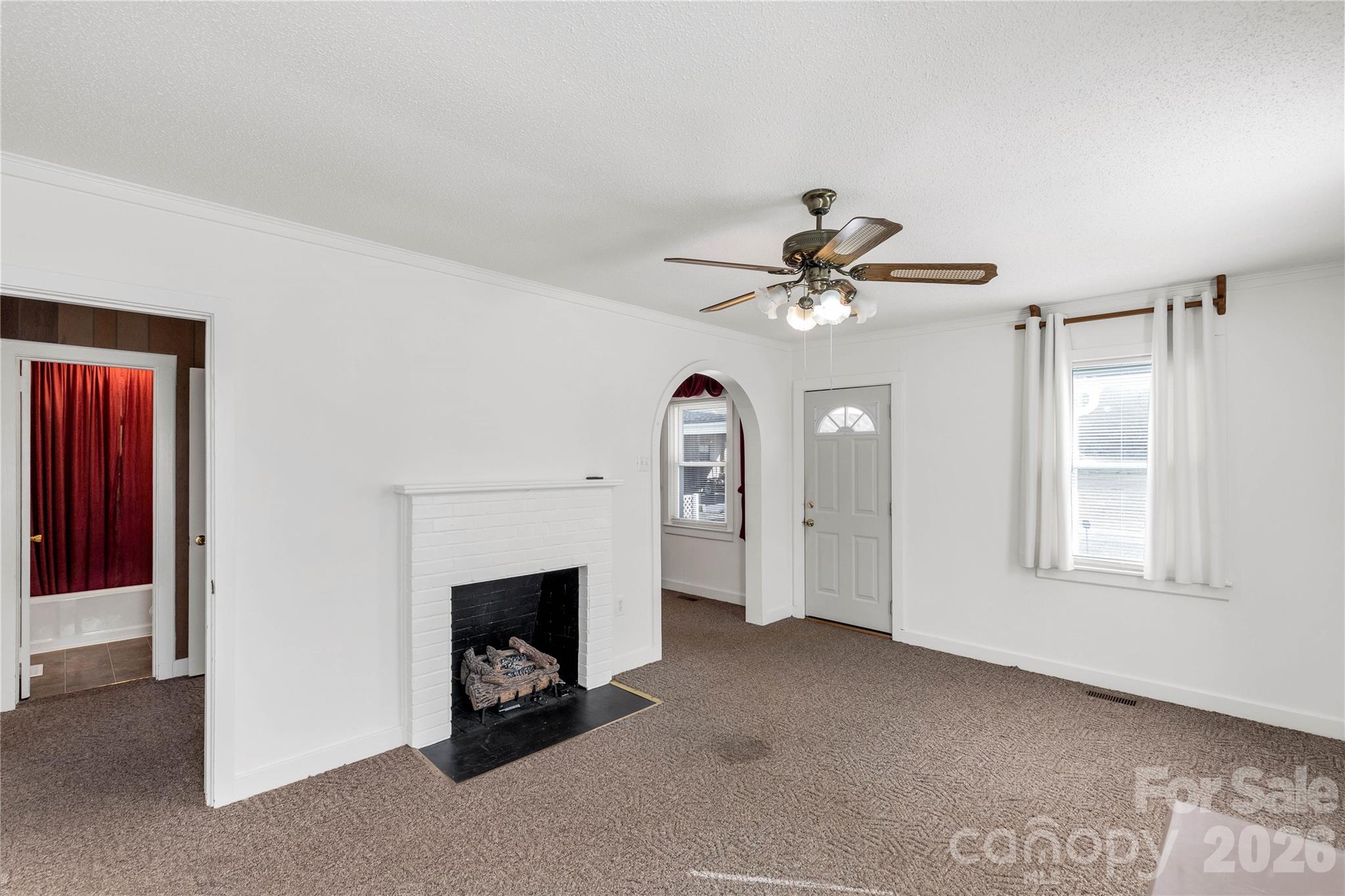 1227 Laurel Avenue Lancaster, SC 29720 - Photo 9 of 48 a view of a livingroom with a ceiling fan a fireplace and a chandelier