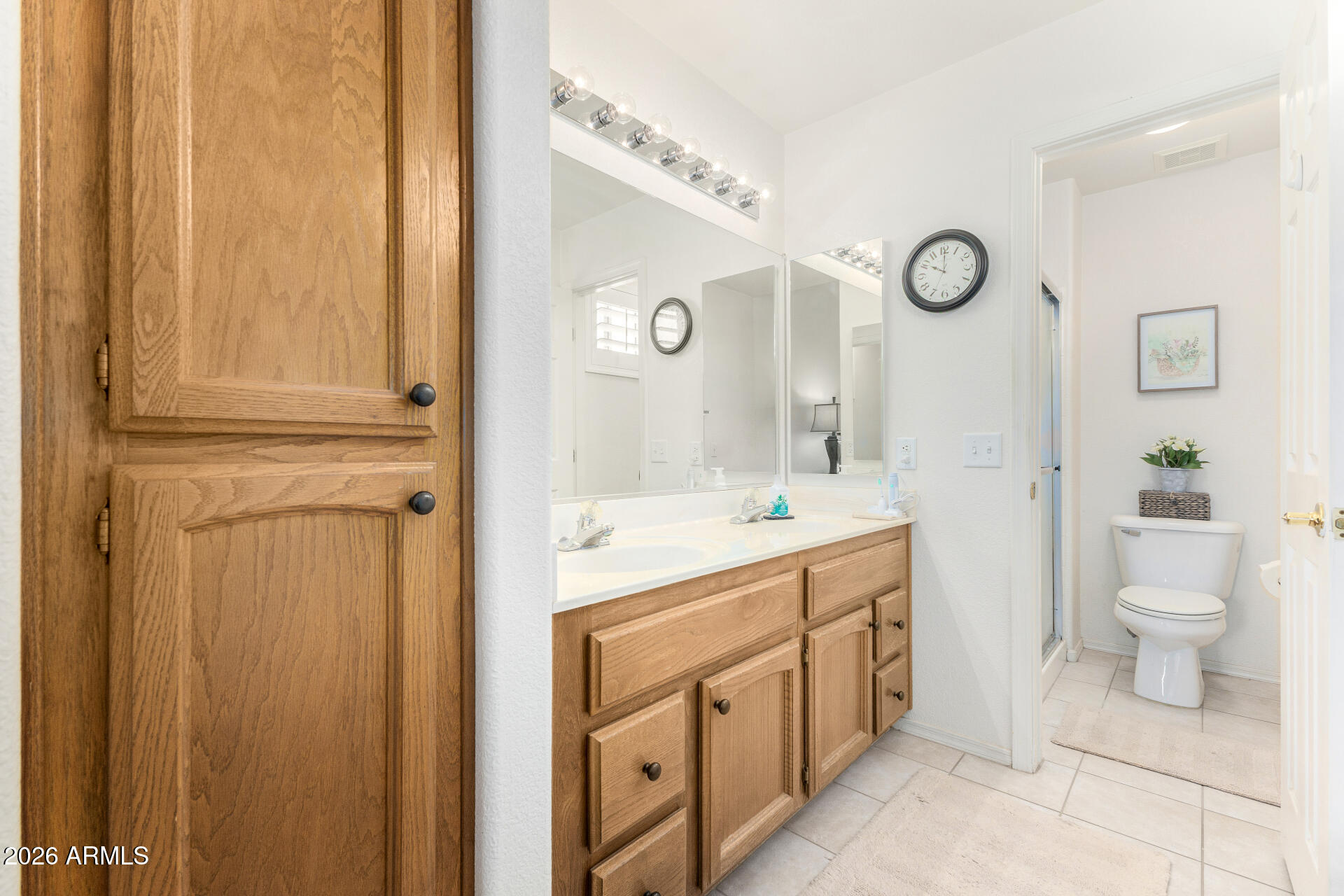 15764 Piccadilly Road Goodyear, AZ 85395 - Photo 18 of 31 a spacious bathroom with a double vanity sink a toilet and a mirror