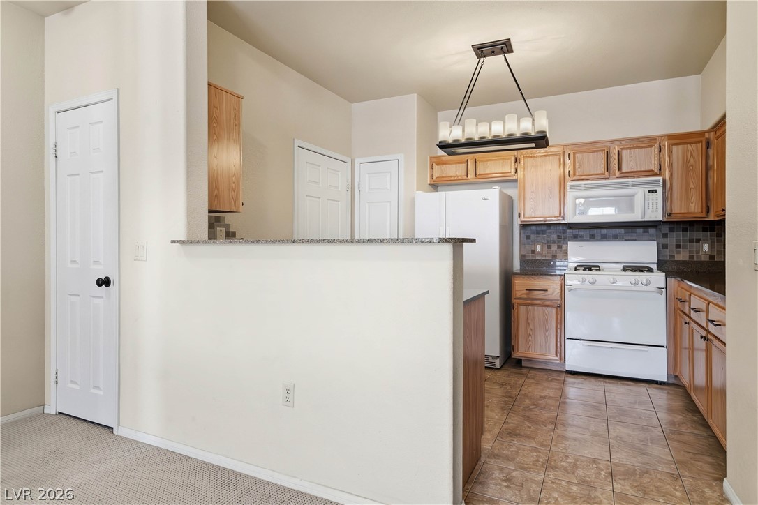 10550 West Alexander Road, Unit 2060 Las Vegas, NV 89129 - Photo 4 of 45 A well-appointed kitchen offers ample counter space and natural wood cabinetry, perfect for culinary endeavors.