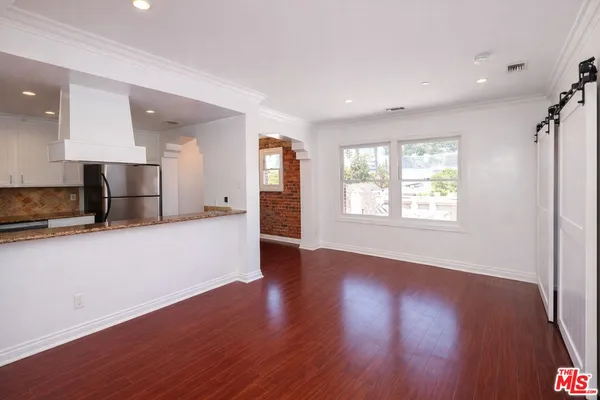 a view of a kitchen with wooden floor and a window