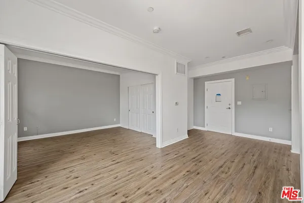 a view of an empty room with wooden floor
