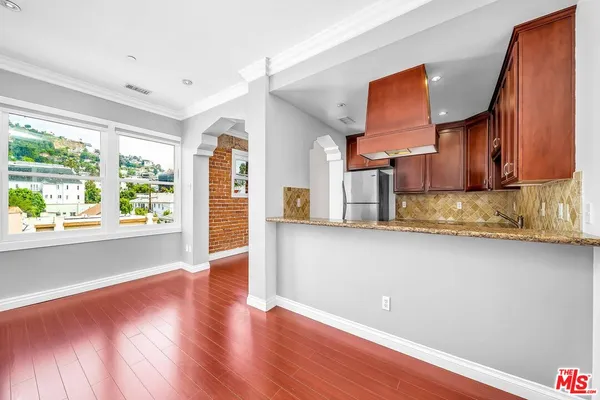 a view of a kitchen with wooden floor and a window