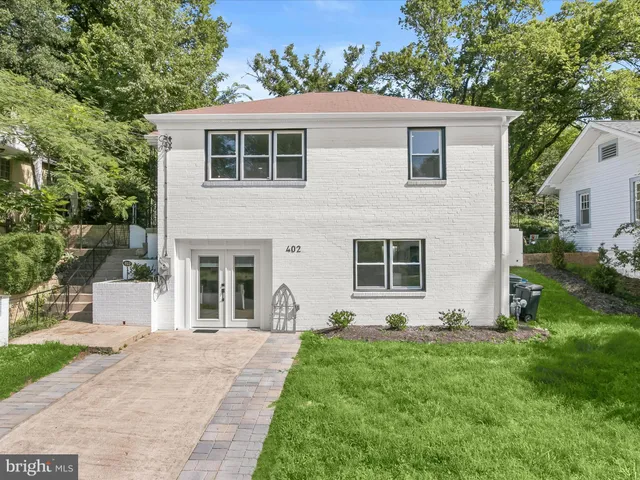 a front view of a house with a yard and potted plants