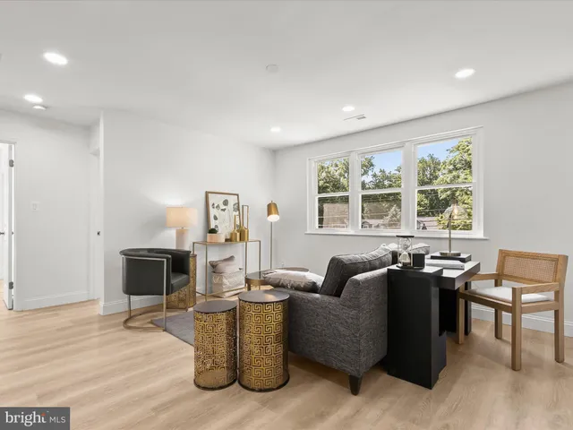 a kitchen with stainless steel appliances granite countertop a stove top oven a sink a dining table and chairs with wooden floor