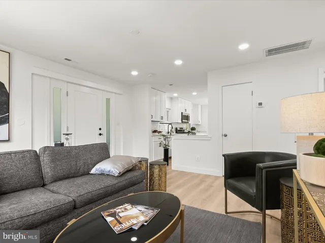 a living room with furniture and a view of kitchen