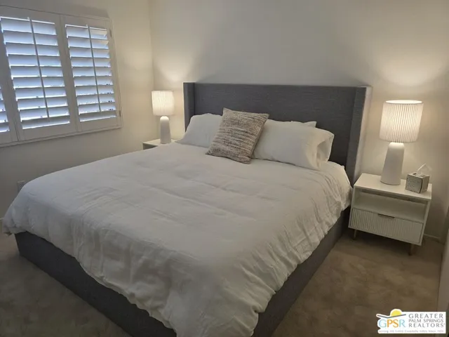 a large bed sitting in a bedroom next to a window