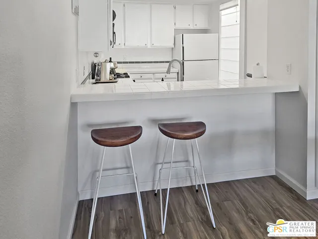 a kitchen with a sink a stove and white cabinets