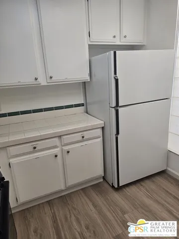 a view of a kitchen with refrigerator and cabinet