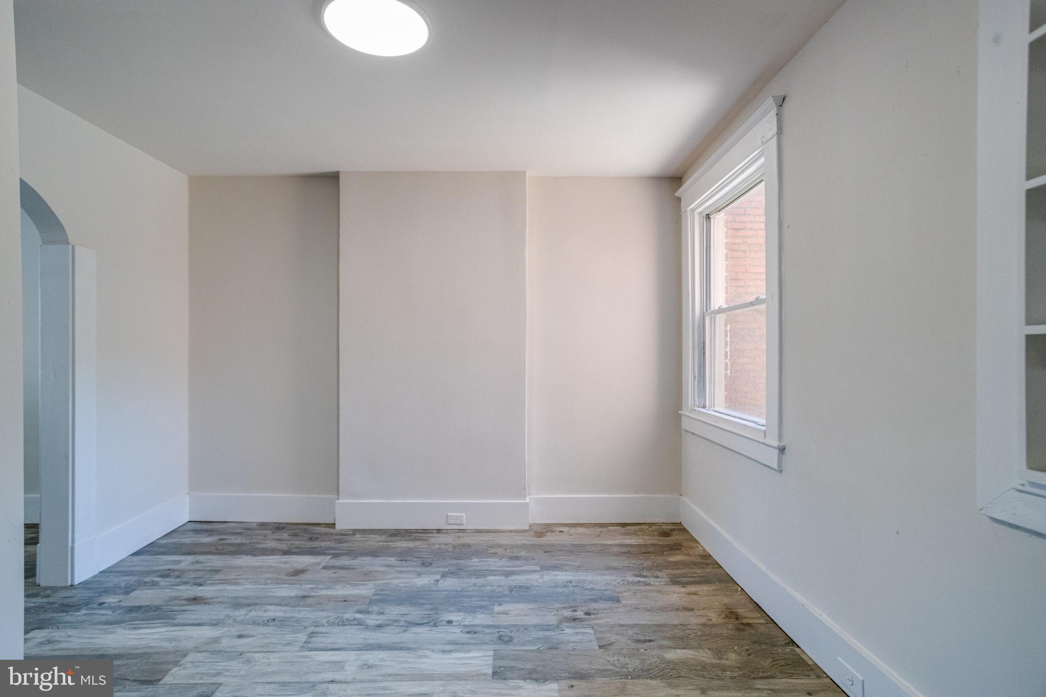 5878 Belair Road Baltimore, MD 21206 - Photo 11 of 41 a view of an empty room with wooden floor and a window