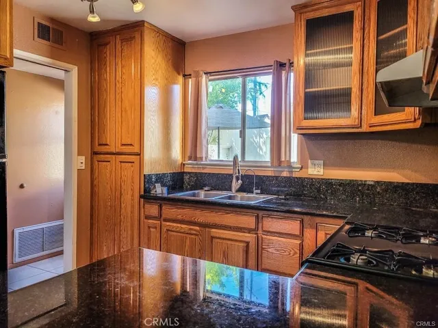 a kitchen with granite countertop a stove and a sink
