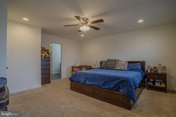 a spacious bedroom with a bed and a ceiling fan