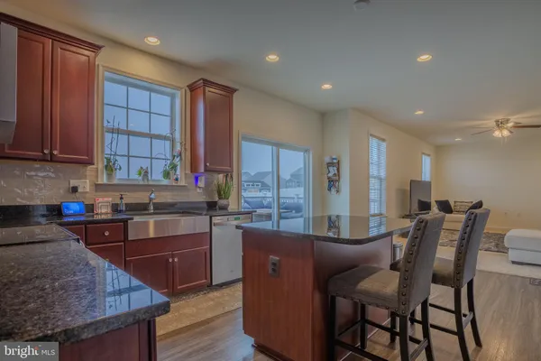 a kitchen with stainless steel appliances granite countertop a stove a sink a dining table and chairs