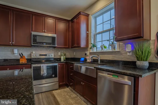 a kitchen with stainless steel appliances granite countertop a stove a sink dishwasher and a microwave oven on the blue kitchen countertops