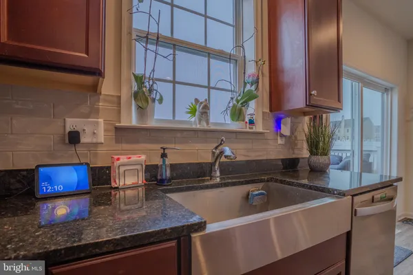a kitchen with stainless steel appliances granite countertop a sink dishwasher and cabinets with wooden floor