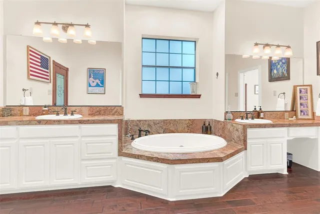 a bathroom with a sink a bathtub a mirror and a bathtub