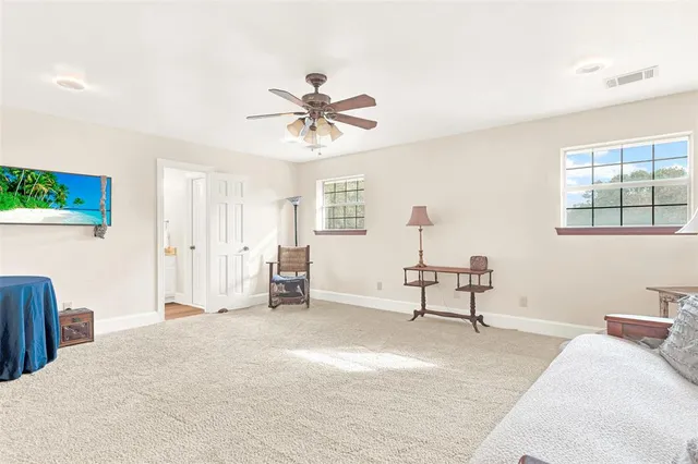 a spacious bedroom with a bed a couch and a window