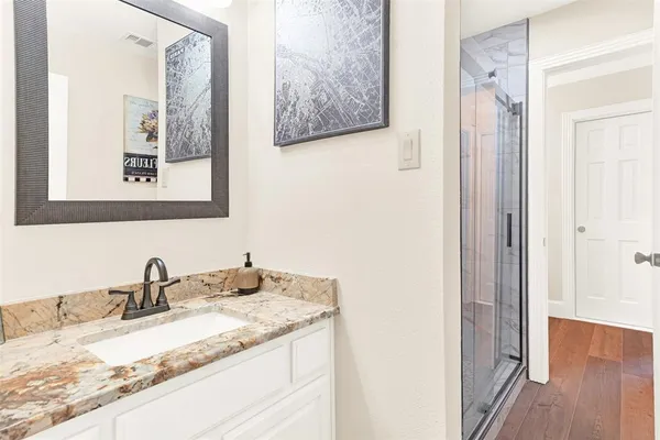 a bathroom with a granite countertop sink and a mirror