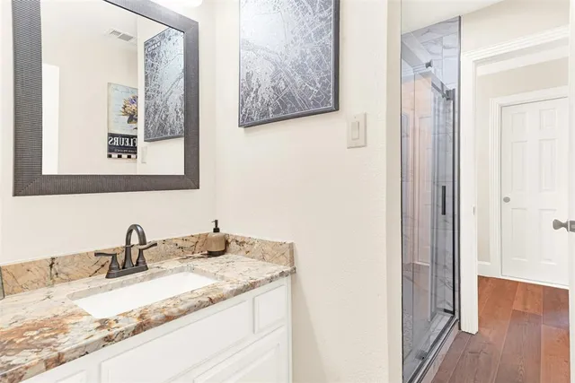 a bathroom with a granite countertop sink and a mirror