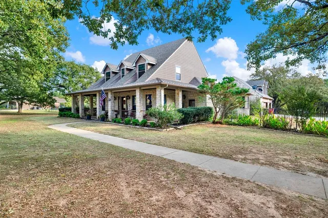 a front view of a house with a yard and trees
