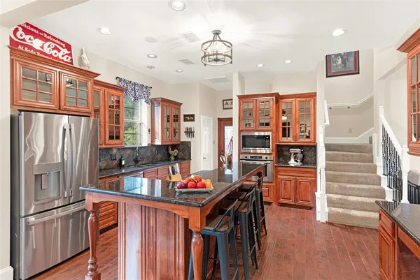 a kitchen with stainless steel appliances granite countertop a refrigerator and a sink